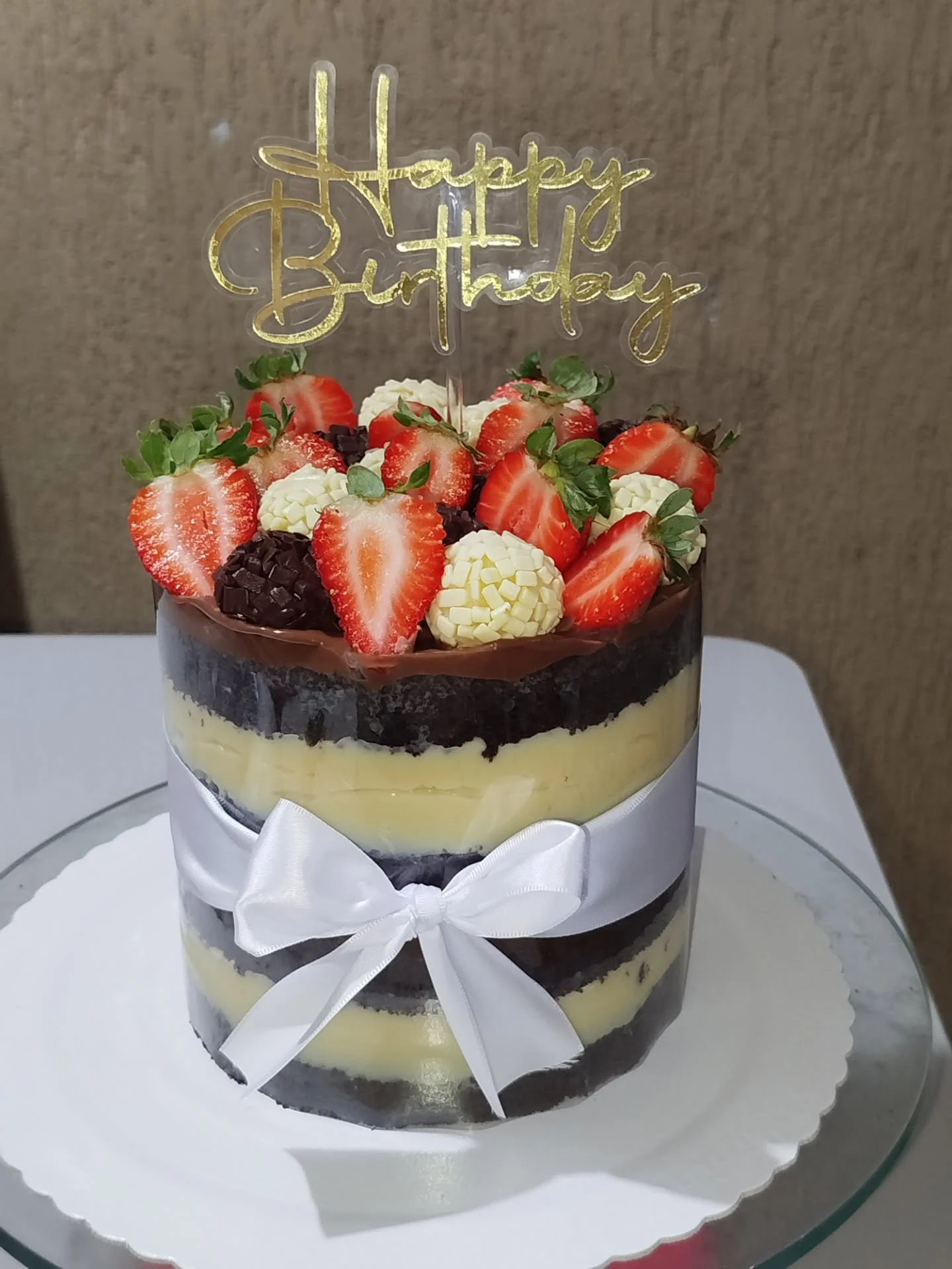 Torta gourmet artesanal com camadas de creme, morangos frescos e brigadeiros enrolados